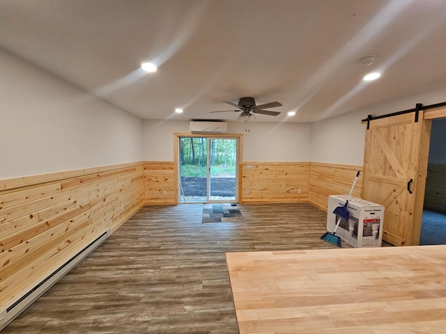 interior space with a wainscoted wall, an AC wall unit, baseboard heating, wooden walls, and ceiling fan