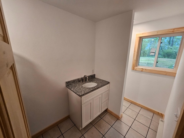 bathroom with baseboards, tile patterned flooring, and vanity