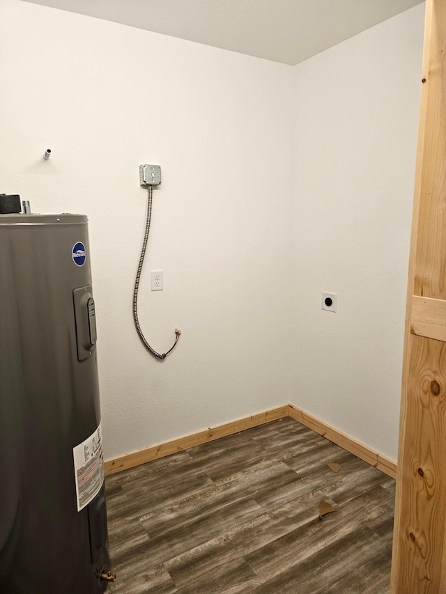 laundry room featuring electric water heater, dark wood-style floors, and baseboards