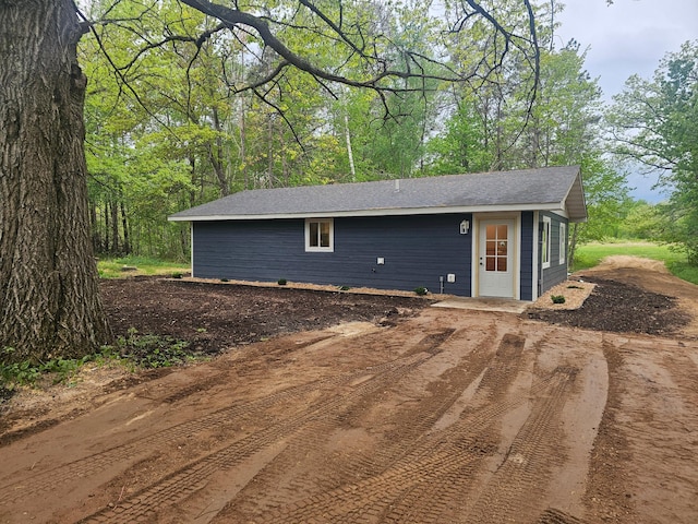 view of property exterior with roof with shingles