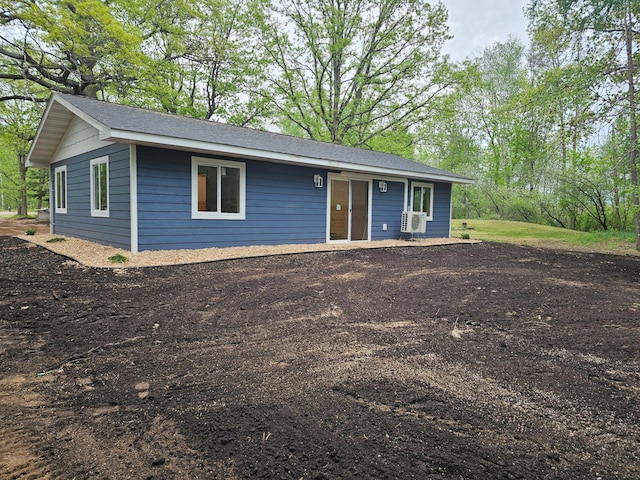 view of front of property featuring cooling unit and roof with shingles