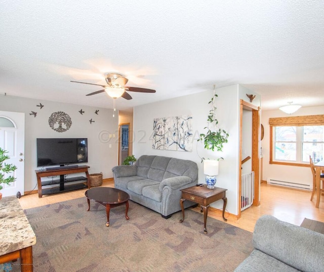 living area featuring a baseboard radiator, light wood-style floors, a ceiling fan, radiator, and a textured ceiling