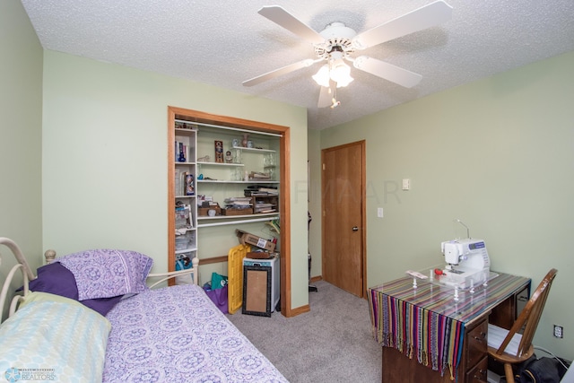 carpeted bedroom with a closet, a textured ceiling, and ceiling fan