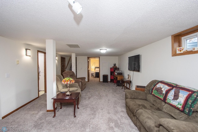 living room with a textured ceiling, light carpet, and baseboards