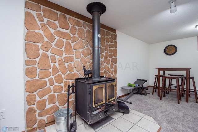 detailed view of a wood stove, carpet, and a textured ceiling