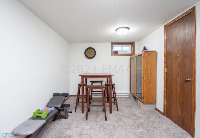 carpeted dining area with a textured ceiling and baseboards