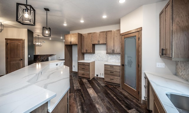 29194 Cynthia Path, Randolph, MN 55065 - kitchen featuring dark wood-type flooring, decorative backsplash, light stone counters, recessed lighting, and hanging light fixtures