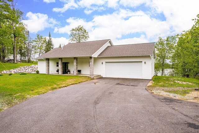 23324 Tioga Beach Rd, Cohasset, MN 55721 - view of front of house with a front lawn, driveway, an attached garage, covered porch, and a shingled roof