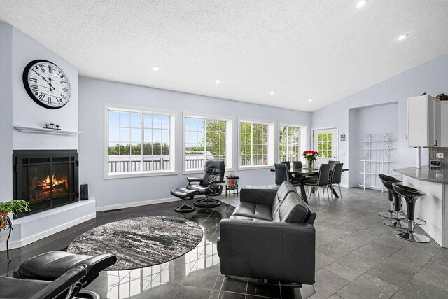 23324 Tioga Beach Rd, Cohasset, MN 55721 - living room with a textured ceiling, plenty of natural light, a lit fireplace, recessed lighting, and baseboards