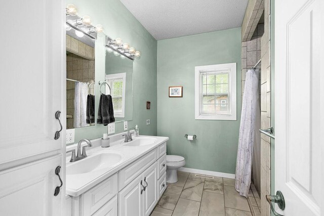 23324 Tioga Beach Rd, Cohasset, MN 55721 - full bathroom featuring toilet, double vanity, a textured ceiling, a shower with shower curtain, and baseboards