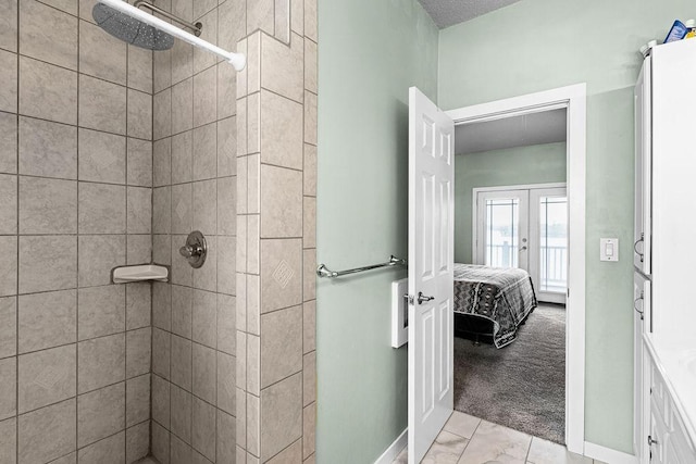 23324 Tioga Beach Rd, Cohasset, MN 55721 - bathroom with french doors, baseboards, marble finish floors, and tiled shower