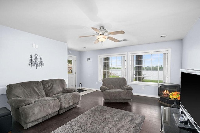 23324 Tioga Beach Rd, Cohasset, MN 55721 - living room with ceiling fan, baseboards, dark wood-style flooring, and a wood stove