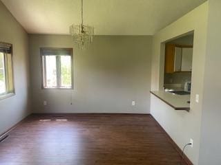 5611 Bavarian Pass, Fridley, MN 55432 - unfurnished dining area with dark wood finished floors, a chandelier, and lofted ceiling
