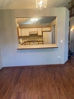 5611 Bavarian Pass, Fridley, MN 55432 - kitchen with fridge, under cabinet range hood, wood finished floors, a peninsula, and baseboards