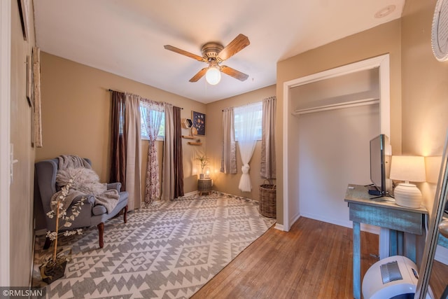 living area with wood finished floors, ceiling fan, and baseboards