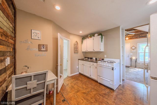 kitchen with white appliances, white cabinets, recessed lighting, and a sink