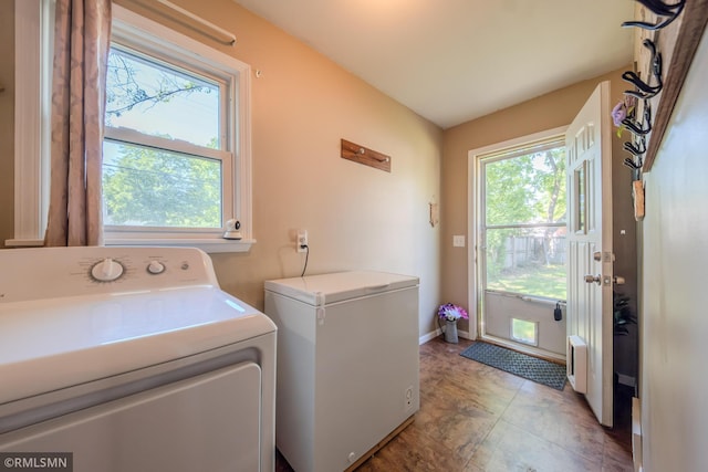 washroom with washer and clothes dryer and baseboards