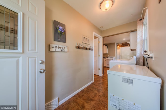 washroom featuring washer and dryer and baseboards