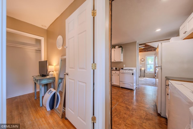 hallway featuring an office area, recessed lighting, washer / dryer, and light wood-style flooring