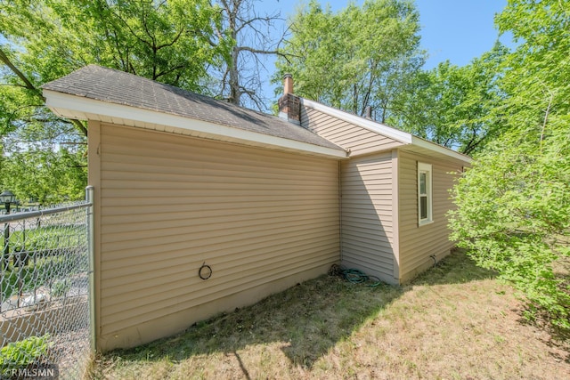 view of home's exterior featuring a shingled roof and a chimney
