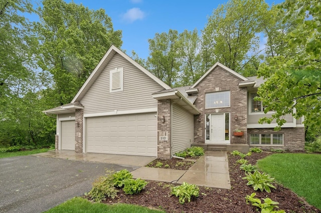 5101 201st St N, Forest Lake, MN 55025 - view of front of home featuring driveway, a garage, and brick siding