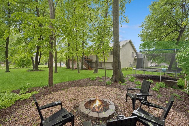 5101 201st St N, Forest Lake, MN 55025 - view of grassy yard featuring a trampoline, a fire pit, and stairs