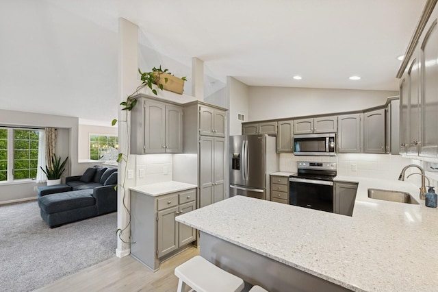 5101 201st St N, Forest Lake, MN 55025 - kitchen featuring stainless steel appliances, a peninsula, a sink, decorative backsplash, and gray cabinetry