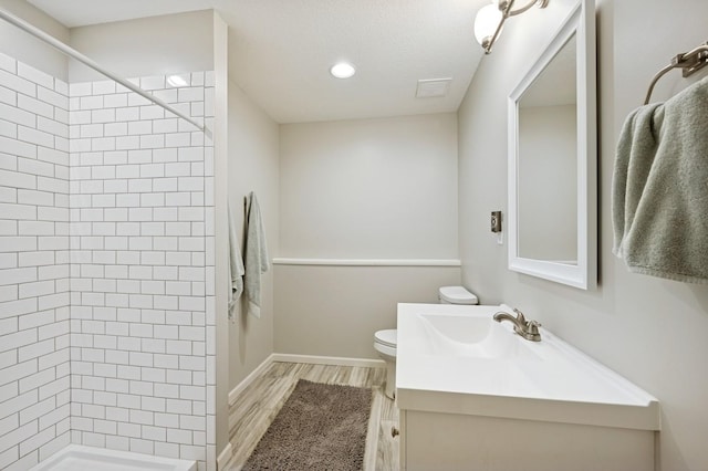 5101 201st St N, Forest Lake, MN 55025 - bathroom with vanity, a tile shower, toilet, wood finished floors, and recessed lighting