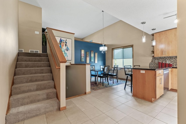 7734 Lancaster Ave NE, Otsego, MN 55301 - kitchen featuring dark countertops, backsplash, a kitchen breakfast bar, a chandelier, and light tile patterned flooring