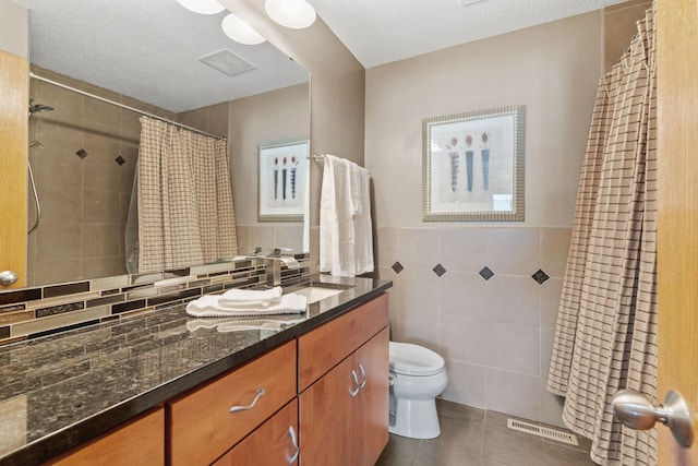 7734 Lancaster Ave NE, Otsego, MN 55301 - bathroom featuring tile walls, tile patterned flooring, vanity, tiled shower, and a textured ceiling