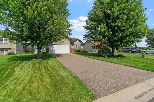 7734 Lancaster Ave NE, Otsego, MN 55301 - view of front facade featuring brick siding, driveway, a front lawn, and an attached garage