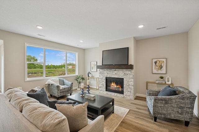 464 Whitewater Ct, Delano, MN 55328 - living area with wood finished floors, a stone fireplace, baseboards, and recessed lighting