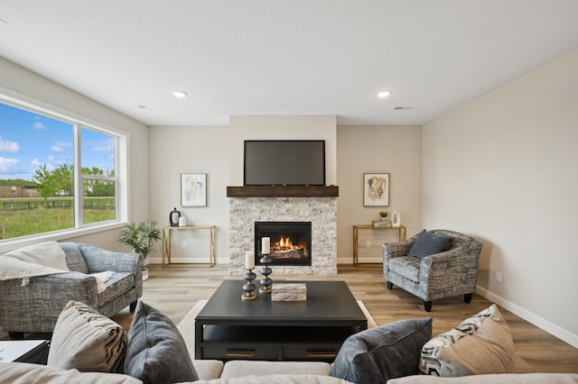 464 Whitewater Ct, Delano, MN 55328 - living room featuring light wood finished floors, baseboards, a stone fireplace, and recessed lighting