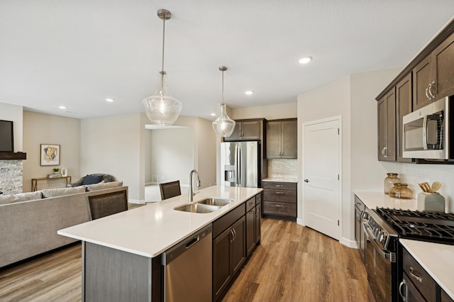 464 Whitewater Ct, Delano, MN 55328 - kitchen with appliances with stainless steel finishes, a sink, open floor plan, dark brown cabinets, and recessed lighting