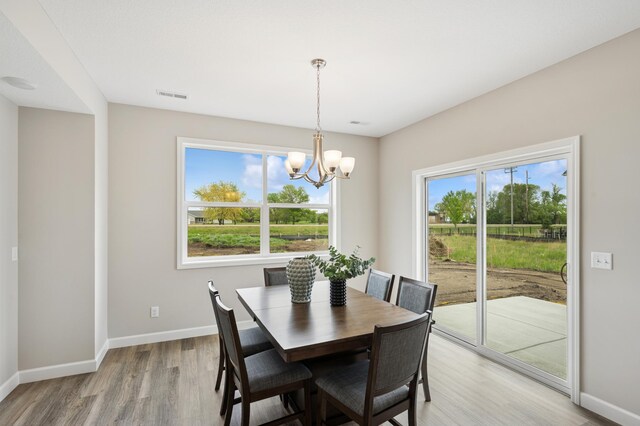 464 Whitewater Ct, Delano, MN 55328 - dining area with a chandelier, light wood-style flooring, and baseboards