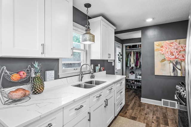 1551 Margaret St, Saint Paul, MN 55106 - kitchen featuring a sink, dark wood-type flooring, white cabinets, decorative light fixtures, and light stone countertops