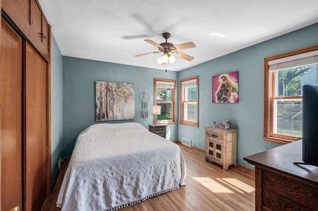 1551 Margaret St, Saint Paul, MN 55106 - bedroom with light wood finished floors, multiple windows, a closet, and baseboards