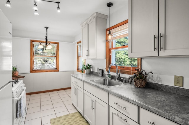 1551 Margaret St, Saint Paul, MN 55106 - kitchen with a sink, gas range gas stove, decorative light fixtures, freestanding refrigerator, and wainscoting