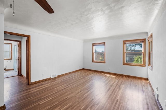 1551 Margaret St, Saint Paul, MN 55106 - spare room with wood finished floors, a textured ceiling, and baseboards