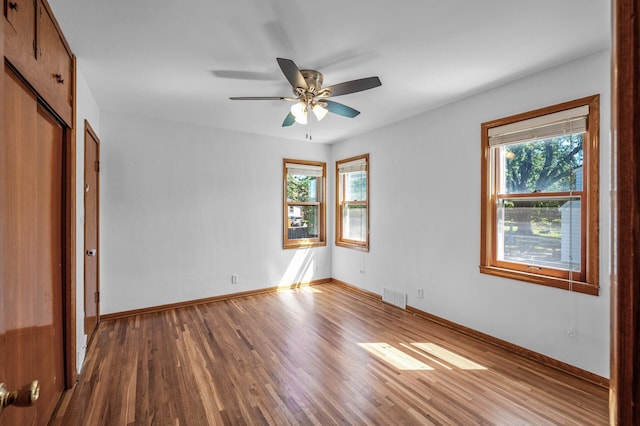 1551 Margaret St, Saint Paul, MN 55106 - unfurnished bedroom with multiple windows, wood finished floors, and baseboards