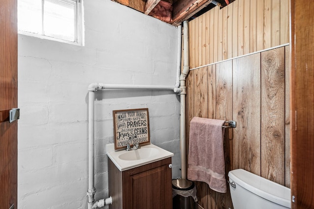 1551 Margaret St, Saint Paul, MN 55106 - bathroom with vanity, toilet, and concrete block wall