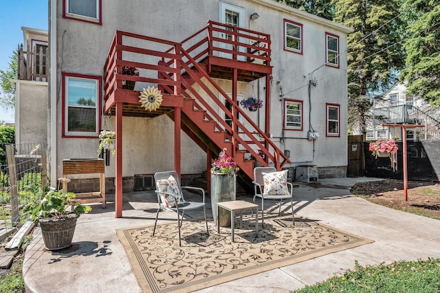 1551 Margaret St, Saint Paul, MN 55106 - back of house featuring stucco siding, a patio, stairs, and a wooden deck