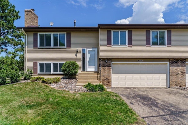 10326 Balsam Ln, Eden Prairie, MN 55347 - split foyer home featuring a garage, a chimney, driveway, and brick siding