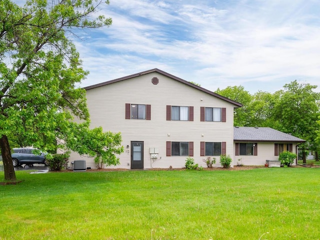 6540 84th Ct N, Brooklyn Park, MN 55445 - rear view of house with a lawn and central AC