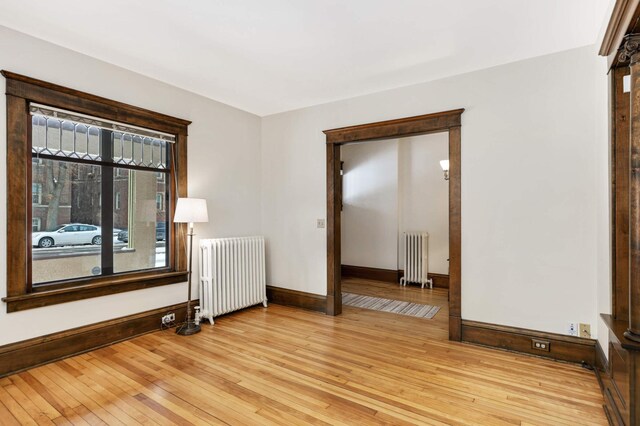 2227 Garfield Ave, Minneapolis, MN 55405 - empty room featuring radiator heating unit, baseboards, and light wood-type flooring
