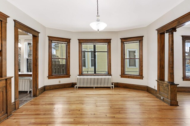 2227 Garfield Ave, Minneapolis, MN 55405 - empty room with radiator, light wood finished floors, and ornate columns