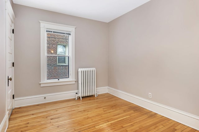 2227 Garfield Ave, Minneapolis, MN 55405 - spare room featuring radiator, light wood-type flooring, and baseboards