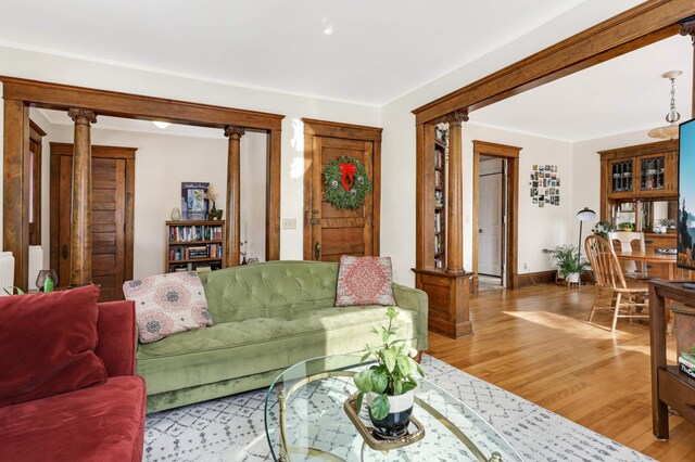 2227 Garfield Ave, Minneapolis, MN 55405 - living area featuring decorative columns, light wood finished floors, and baseboards