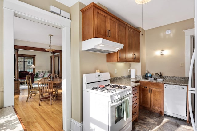 2227 Garfield Ave, Minneapolis, MN 55405 - kitchen with white appliances, under cabinet range hood, brown cabinetry, and a sink