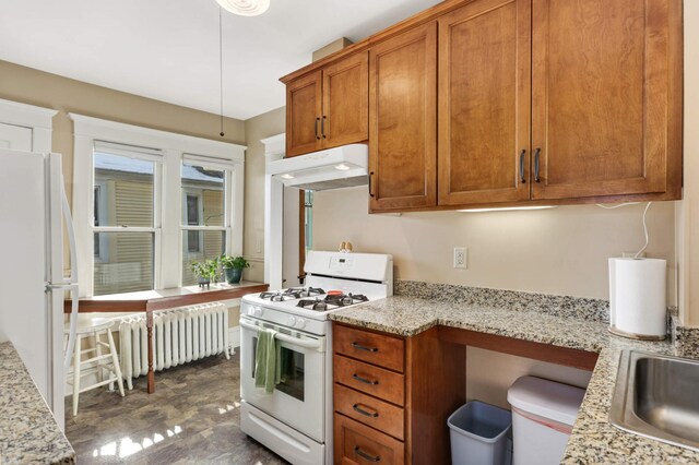 2227 Garfield Ave, Minneapolis, MN 55405 - kitchen with white appliances, under cabinet range hood, radiator heating unit, brown cabinetry, and light stone counters